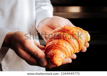 Yummy croissant. Nice little yummy French croissant in hands of professional bake