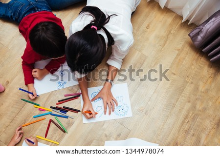 Top view Family happy children group kid boy and girl kindergarten paint drawing on peper with teacher education together at interior playroom
