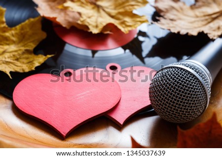 Song for lovers. Nostalgic songs, fallen autumn leaves and melancholy. Concept with vinyl records, microphone and hearts. Royalty-Free Stock Photo #1345037639