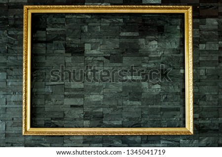 Golden picture frame hangon black brick wall background