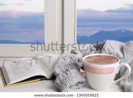 Composition with cup of hot winter drink on windowsill