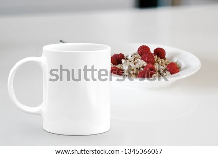 White mug next to a bowl of cereal. Perfect for businesses selling mug mockups