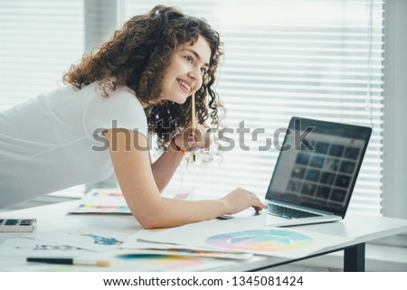 The woman working with a brush and a laptop