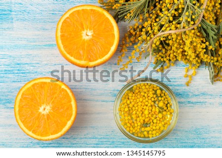 Beautiful flowers of yellow mimosa and orange on a blue wooden background. top view. close-up