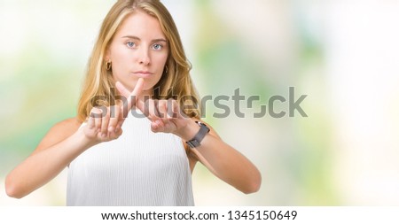 Beautiful young elegant woman over isolated background Rejection expression crossing fingers doing negative sign
