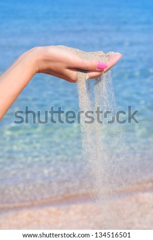 sand pour away through the hands against sea, instability concept