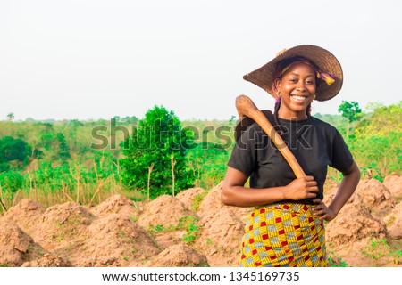 portrait of a local young black female farmer smiling Royalty-Free Stock Photo #1345169735