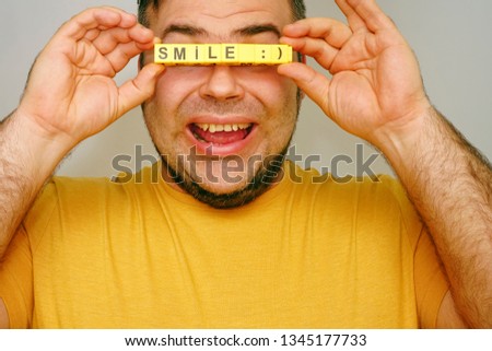 no eyes. unrecognizable person. Many fingers Holding the Word - smile. isolated on gray Background. happy face
