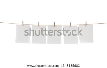 White blank photo cards hanging on clothesline.