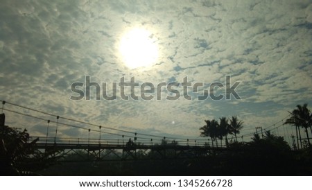 bridge with a blue sky background covered in white clouds exposed to sunlight