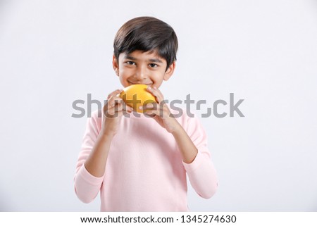 Cute indian/Asian little boy eating Mango with multiple expressions. isolated over white background