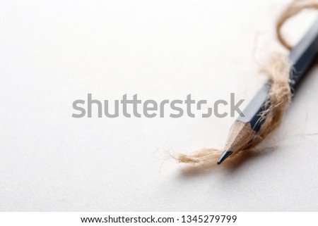 Gray pencil with a rope on the right side of a white background. Education concept. copyspace