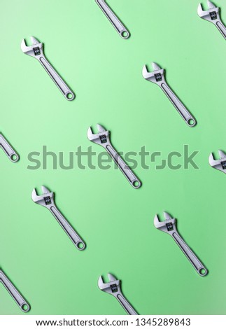 The pattern of adjustable wrenches on a green background.