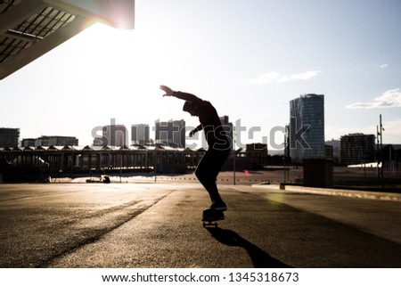 man riding and jumping with a skate in front of buildings and walls from the city of Barcelona