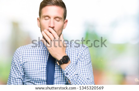 Handsome business man wearing tie bored yawning tired covering mouth with hand. Restless and sleepiness.