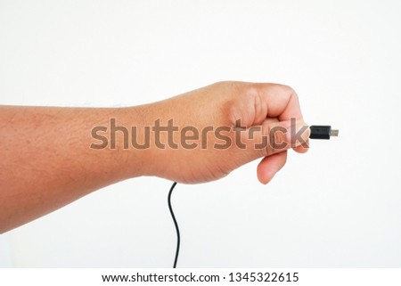Hand holding a USB cable isolated on white background.