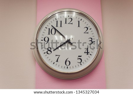 Simple analog clock on white wall loft concrete wall.