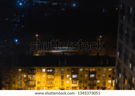 Building with people silhouettes in windows. Casual urban city life. Traffic on the road. People waite bus on busstop with traffic light. Aerial panoramic view from tower rooftop.
