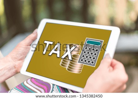 Female hands holding a tablet with tax concept