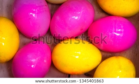 Colorful easter eggs yellow and pink inside wooden box