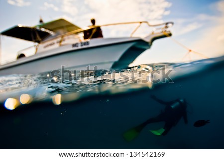 Scuba diver swims under a boat