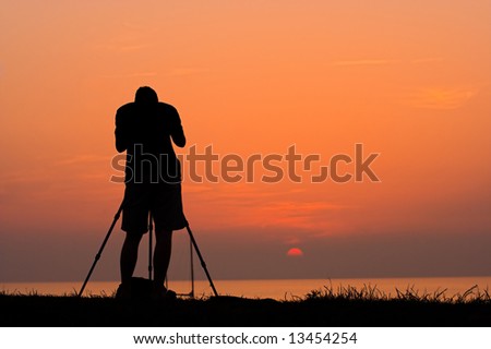Silhouette of a photographer taking photos of a sunset