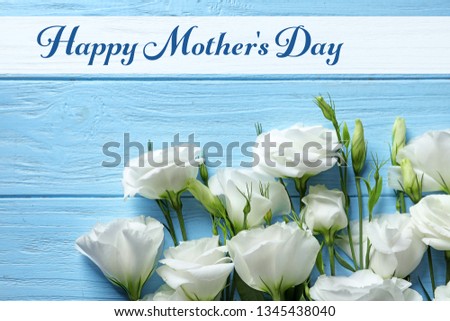 Beautiful eustoma flowers and text Happy Mother's Day on wooden background, top view