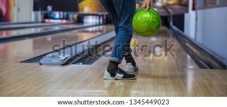 Happy Young woman throwing ball in bowling club- People, leisure, sport and entertainment concept
