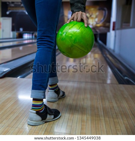 Happy Young woman throwing ball in bowling club- People, leisure, sport and entertainment concept