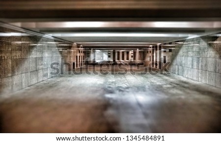 New, empty, underpass, with marble floor and walls, spotlights, and gloomy furnishings