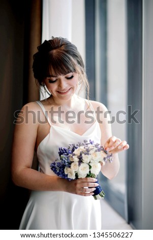 Portrait of a beautiful Russian girl-bride in boudoir dress and wedding, with a bouquet. Photos of the morning and walk.