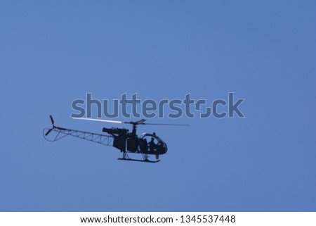 A small helicopter flying in the sky