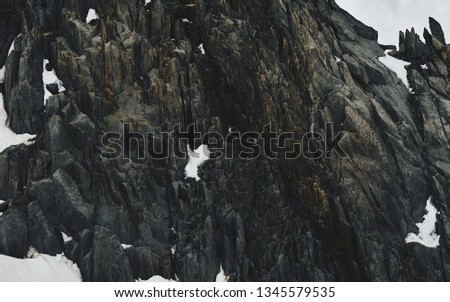 Mountains covered by snow and ice with dark rocks