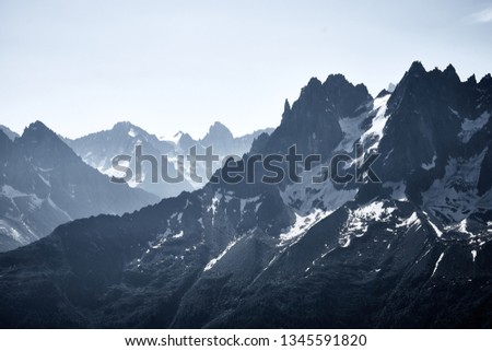 Mountains covered by snow and ice with dark rocks
