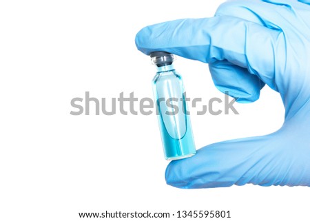 Doctor or scientist is showing in hand a blue liquid in a transparent bottle. A vaccination concept background.