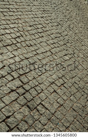 Close-up of pavement made of granite setts on alley in a sunny day, forming a singular background at Elvas. A gracious star-shaped fortress city on the easternmost frontier of Portugal.