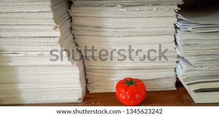 Pomodoro timer in background of paper textures piled.