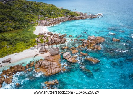 Aerial view of Seychelles tropical Marron beach at La Digue island. White sand beach with turquoise ocean water and quaint granite rocks. tropical paradise Royalty-Free Stock Photo #1345626029
