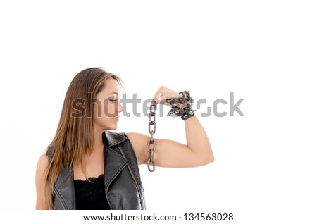 Young gang girl showing her biceps in studio with chains
