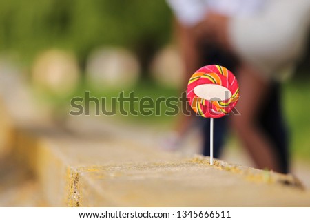 Candy on a stick on the background of a couple