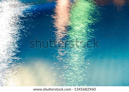 Abstract background, texture of blue water with multicolored highlights on it. Horizontal frame