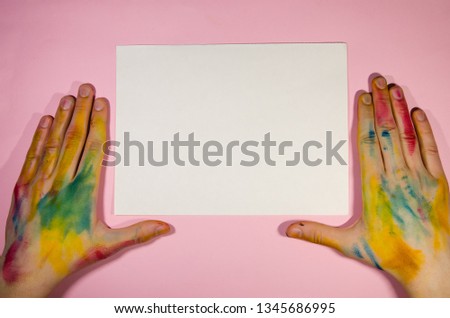 Painter hands from the view from above on the pink background. Paper for mokeup and copy space. Be creative and draw concept.
