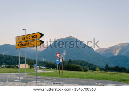 Road signs on a road going through mountains, meadows and forest in Triglav National Park, Slovenia