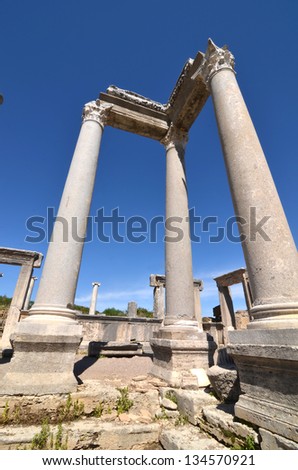 Greek corinthian columns complete with entablature and architrave with doorways and lintels in the background