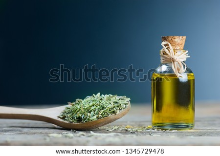 thyme essential oil and Heap of dry thyme in wooden spoon or shovel on wooden background. Dried spice zahter thyme and oil concept Royalty-Free Stock Photo #1345729478