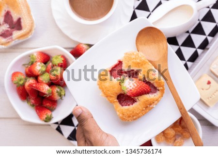 human man hold dish of strawberry pie.