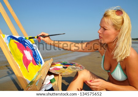Woman paints on the beach
