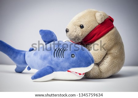 Portrait of soft cuddle old teddy bear with red scarf and shark isolated on  gray background Royalty-Free Stock Photo #1345759634