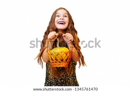 Little girl with long hair in witch clothes, holding a pumpkin, emotional portrait on a white background