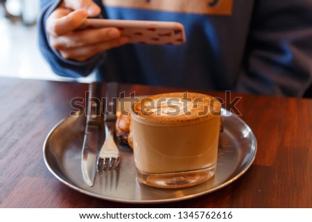 taking pictures of dessert with smartphone in the cafe (social eating)